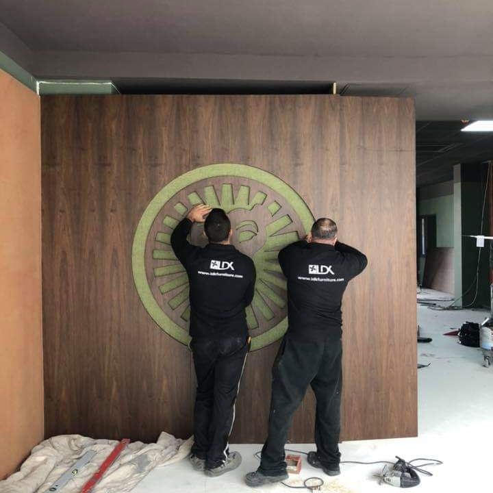 MEN WORKING ON SIGN CUT BY CNC